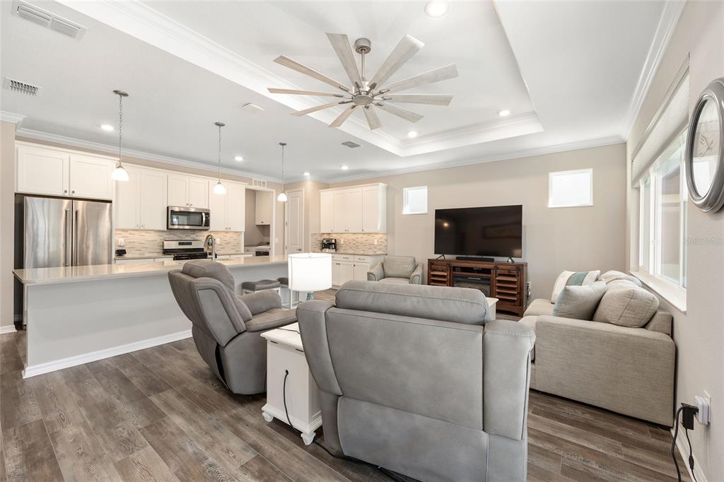 10390 Southwest 99th Street Ocala, FL 34481 - Photo 30 of 48 a living room with furniture a flat screen tv and a chandelier