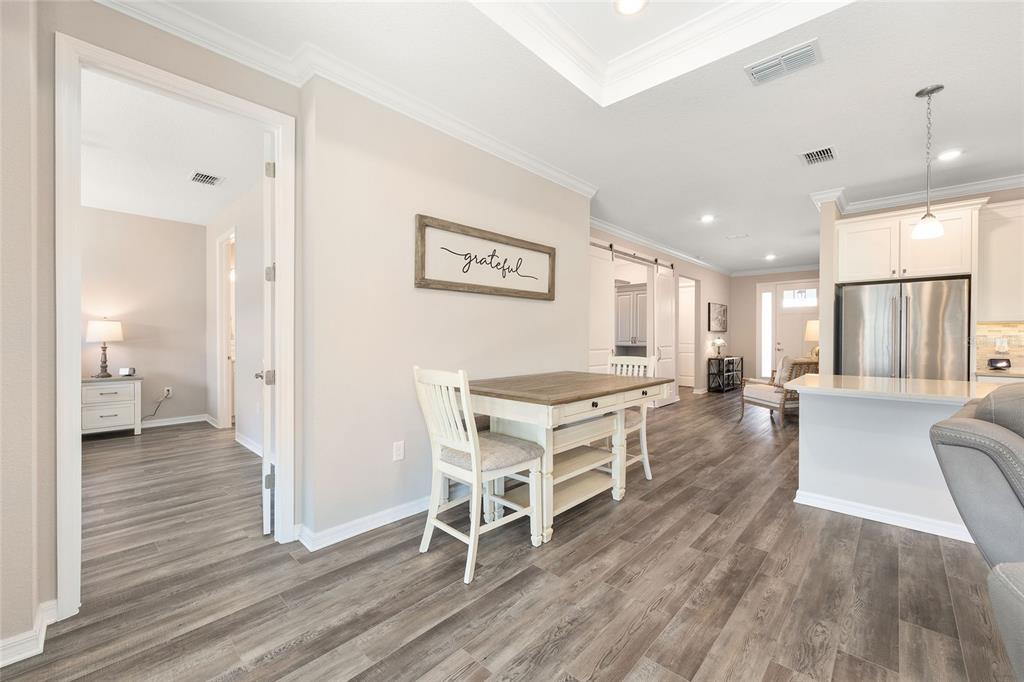 10390 Southwest 99th Street Ocala, FL 34481 - Photo 34 of 48 a living room with furniture a wooden floor and a refrigerator