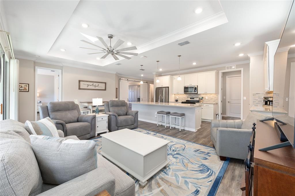 10390 Southwest 99th Street Ocala, FL 34481 - Photo 35 of 48 a living room with furniture kitchen view and a chandelier