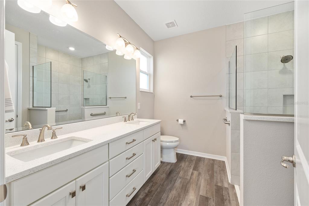 10390 Southwest 99th Street Ocala, FL 34481 - Photo 40 of 48 a bathroom with a double vanity sink mirror and toilet