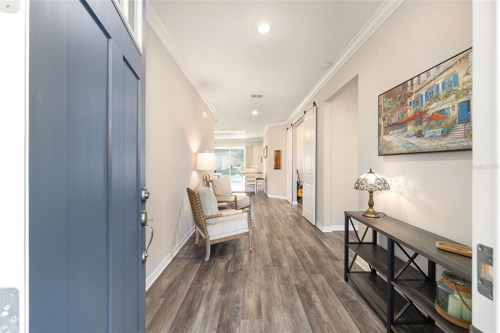 10390 Southwest 99th Street Ocala, FL 34481 - Photo 9 of 48 a view of a hallway with wooden floor and furniture