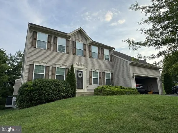 a front view of a house with a garden and yard