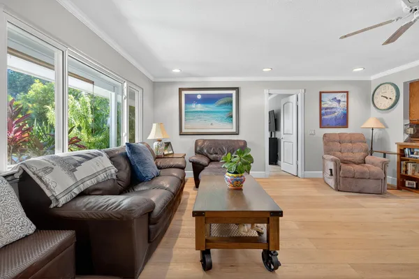 a living room with furniture a chandelier and a dining table with wooden floor