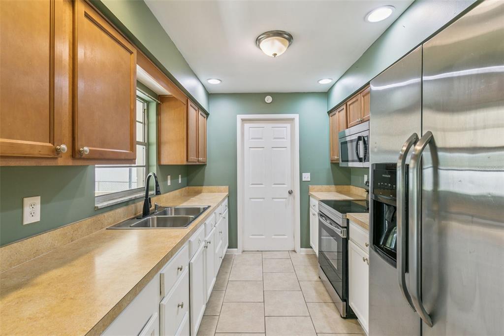 111 Amigos Road DeBary, FL 32713 - Photo 11 of 29 a kitchen with a sink refrigerator and cabinets