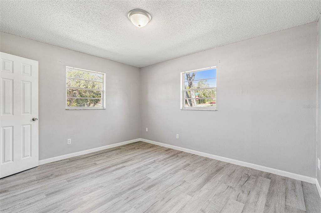 111 Amigos Road DeBary, FL 32713 - Photo 15 of 29 an empty room with wooden floor and windows