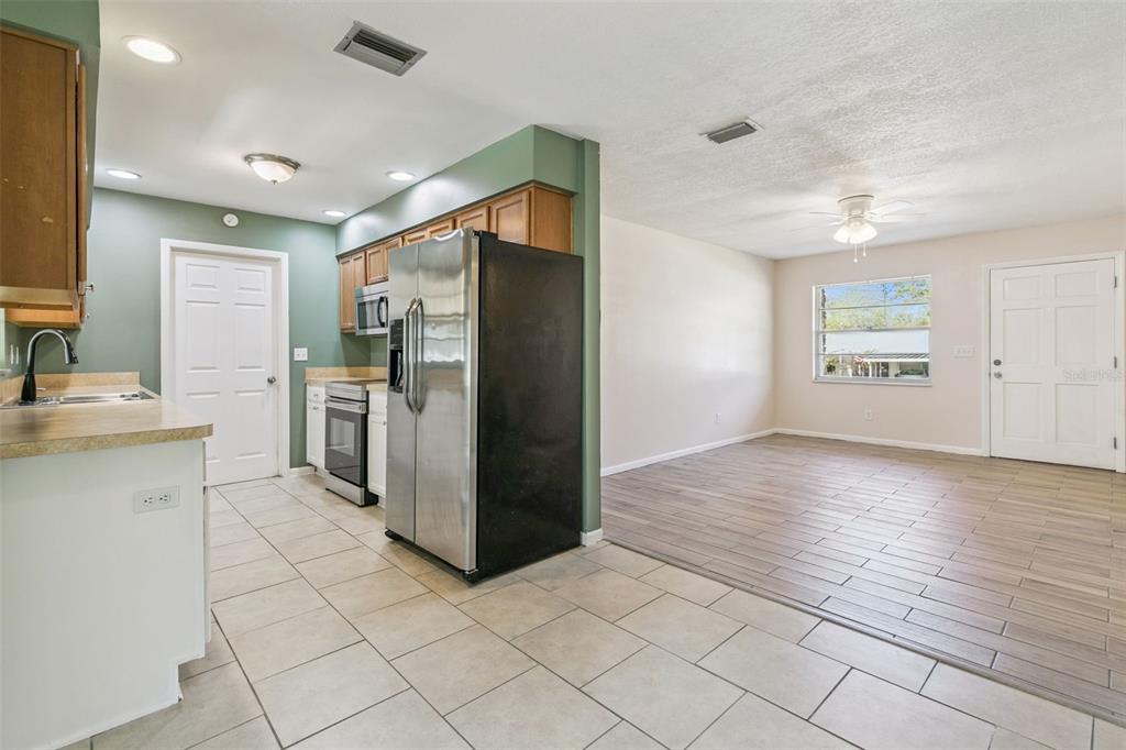 111 Amigos Road DeBary, FL 32713 - Photo 4 of 29 a kitchen with granite countertop a refrigerator and a stove top oven