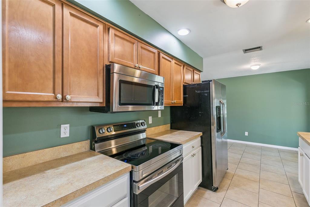 111 Amigos Road DeBary, FL 32713 - Photo 8 of 29 a kitchen with stainless steel appliances granite countertop a refrigerator and a microwave