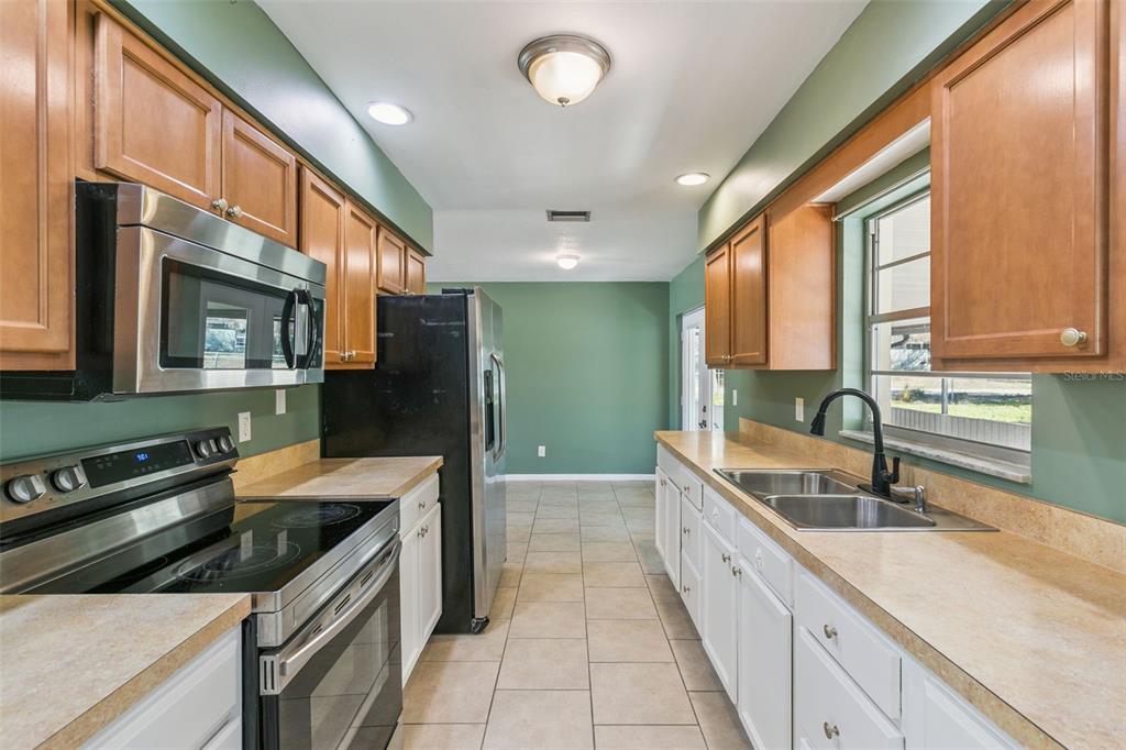 111 Amigos Road DeBary, FL 32713 - Photo 10 of 29 a large kitchen with stainless steel appliances granite countertop a sink and a stove