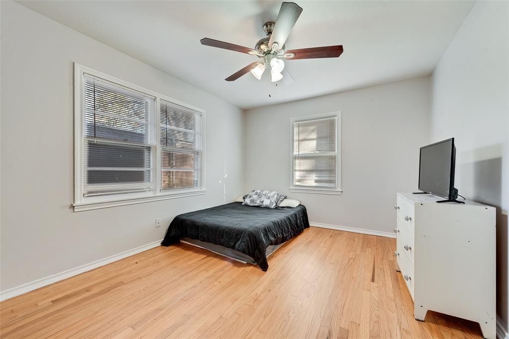 11310 Sinclair Avenue Dallas, TX 75218 - Photo 16 of 26 a bedroom with a bed and a flat tv screen on a dresser