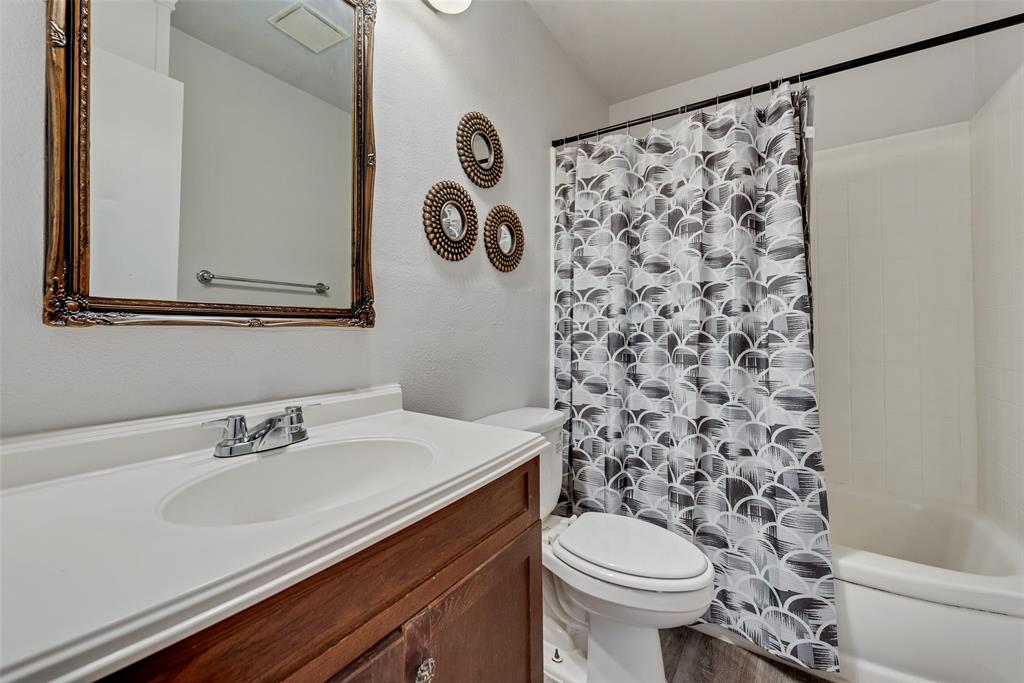 11310 Sinclair Avenue Dallas, TX 75218 - Photo 17 of 26 a bathroom with a sink toilet and a mirror