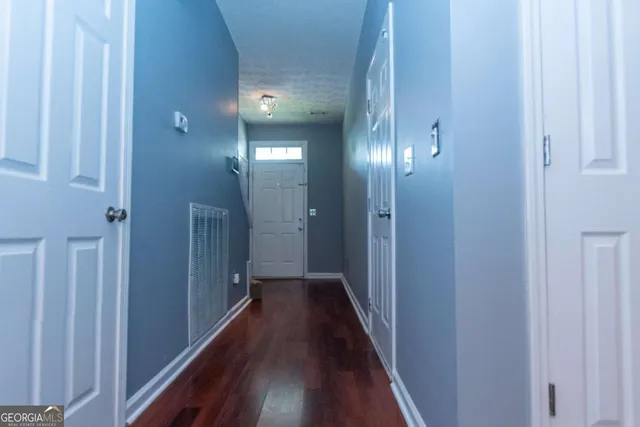 a view of a hallway with wooden floor