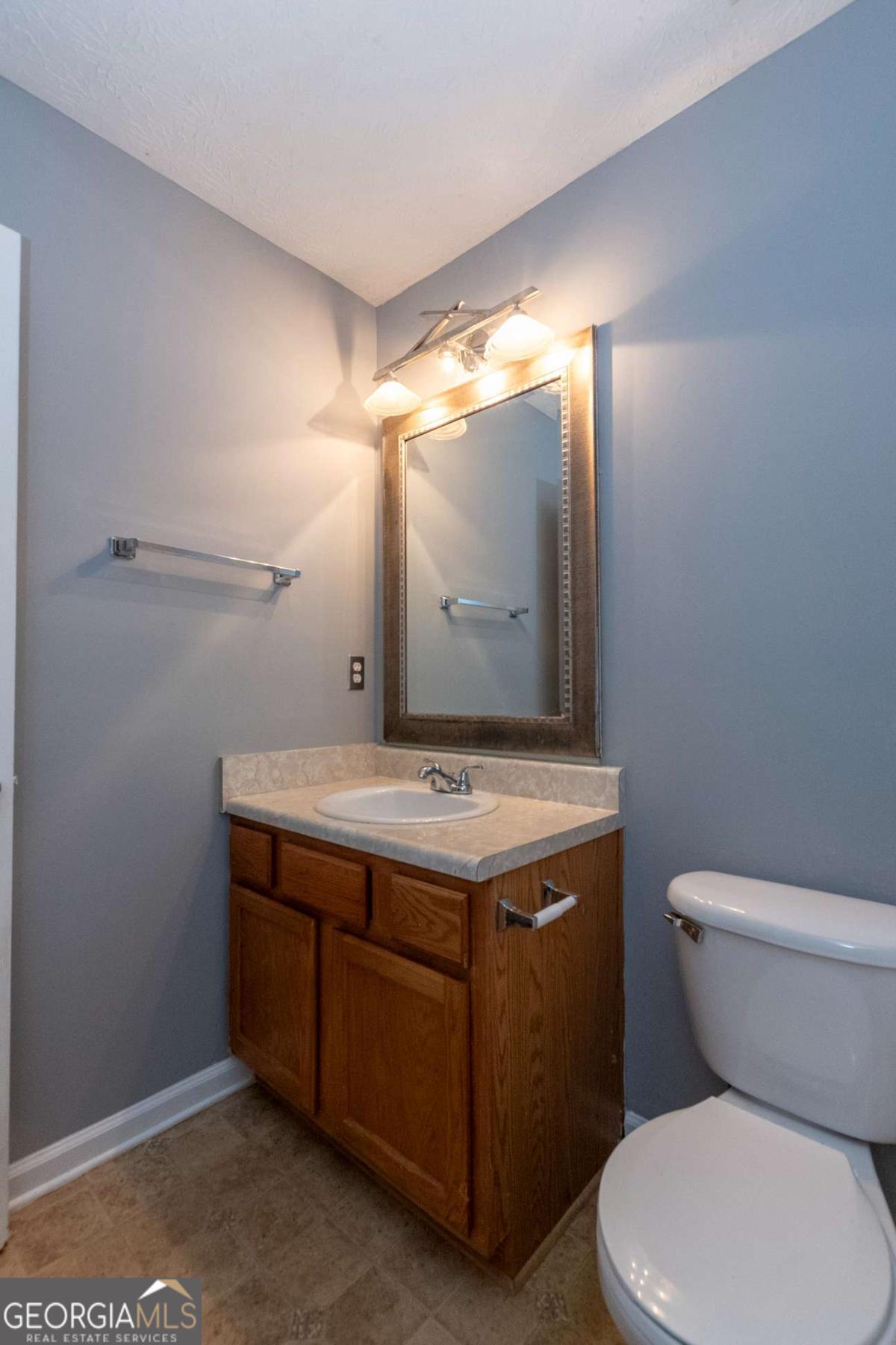 4123 Stone Trace Drive East Point, GA 30344 - Photo 3 of 24 a bathroom with a granite countertop toilet sink and mirror
