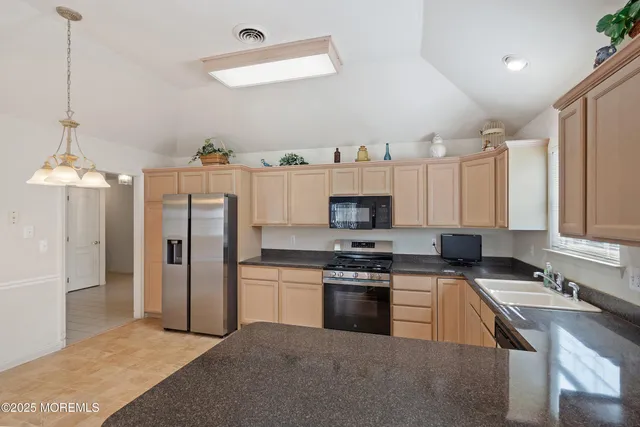 a kitchen with stainless steel appliances granite countertop a stove refrigerator and a sink