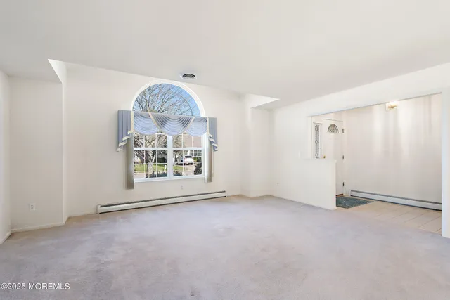 an empty room with a ceiling fan and window