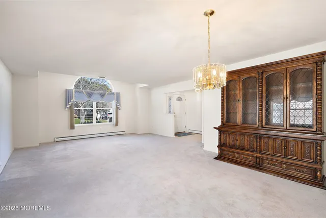 a view of a livingroom with furniture large windows and a chandelier