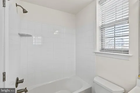 a bathroom with a sink a toilet and a window