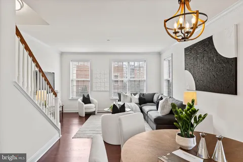 a living room with couches a dining table and a couches with wooden floor