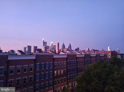 a multi story building with swimming pool and red chairs