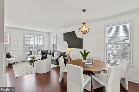 a living room with furniture wooden floor and a large window