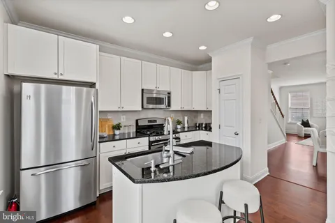 a kitchen with stainless steel appliances granite countertop a sink a stove and a refrigerator