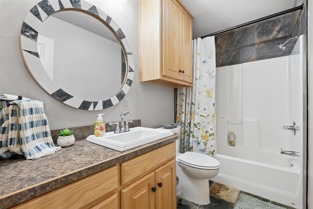 186 West Hells Gate Drive Strawn, TX 76475 - Photo 18 of 40 a bathroom with a sink a toilet and a mirror