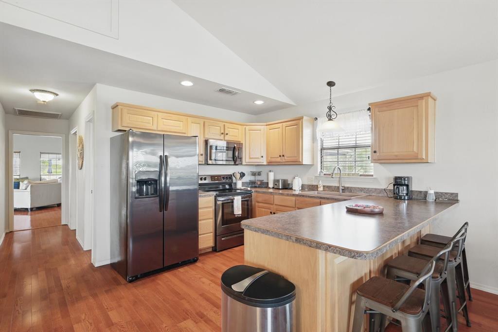 186 West Hells Gate Drive Strawn, TX 76475 - Photo 10 of 40 a kitchen with stainless steel appliances granite countertop a sink a stove a refrigerator cabinets and dining table