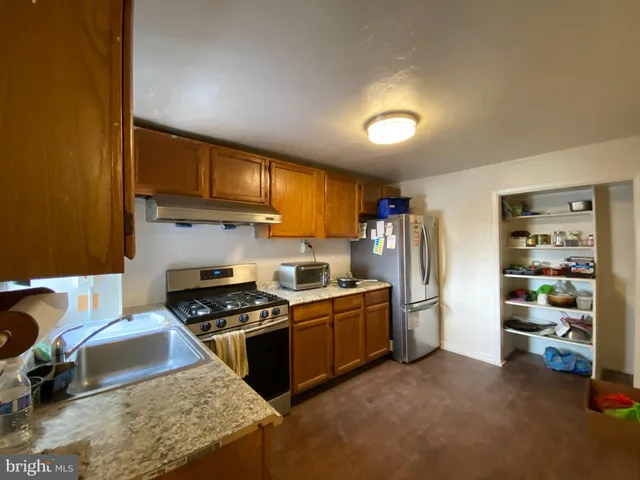 a kitchen with stainless steel appliances granite countertop a stove refrigerator and cabinets