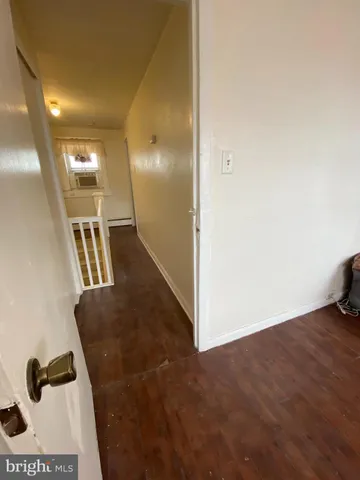 a view of hallway with stairs and wooden floor