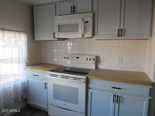 a kitchen with white cabinets appliances and sink
