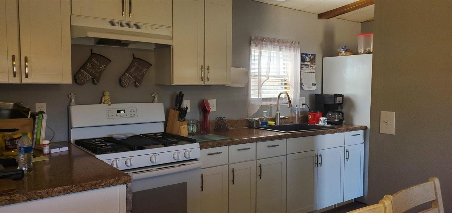 716 West 8th Street Post, TX 79356 - Photo 5 of 14 a kitchen with a sink stove and cabinets