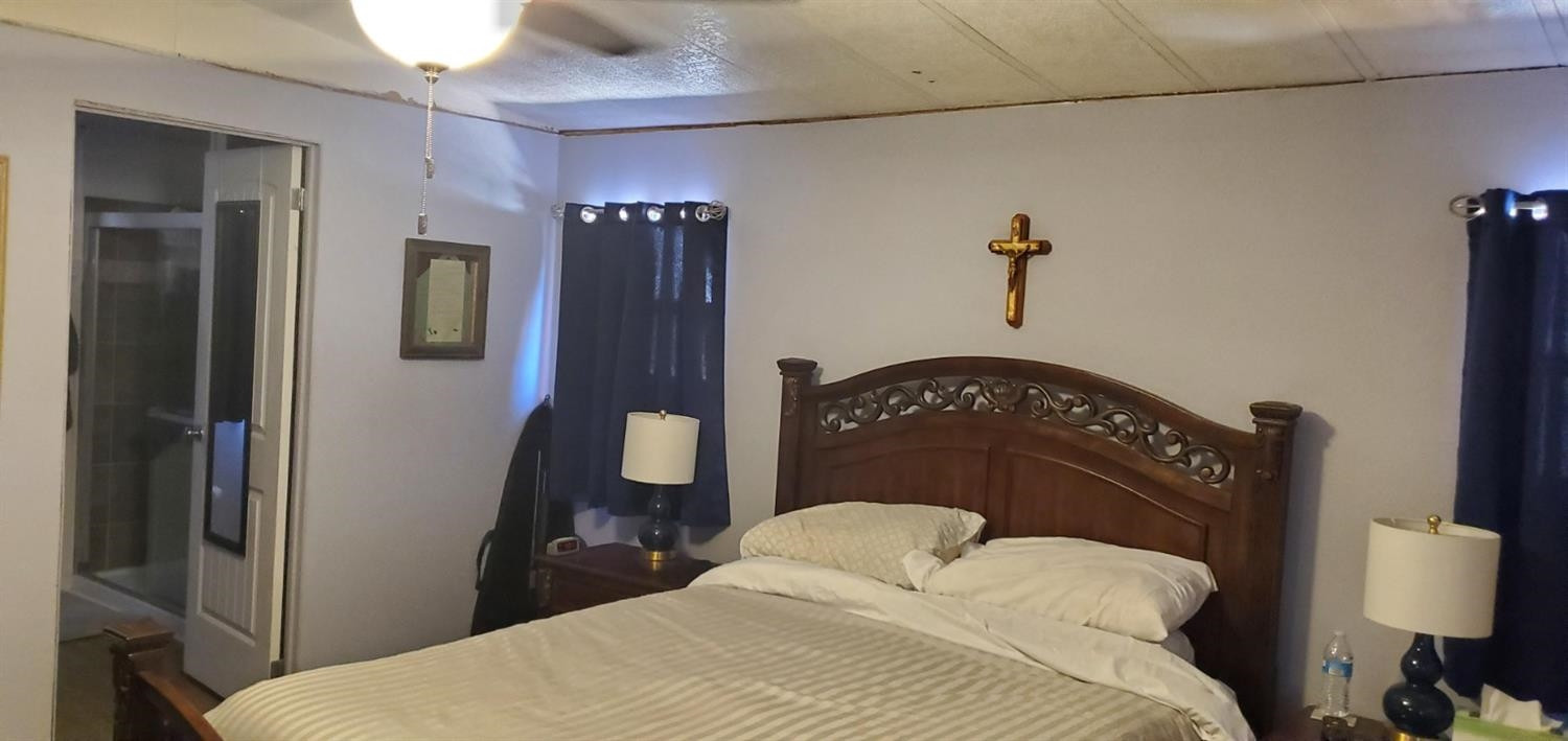 716 West 8th Street Post, TX 79356 - Photo 7 of 14 a bedroom with a bed and a lamp on the wall