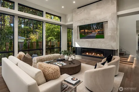 a kitchen with stainless steel appliances granite countertop a stove top oven a sink a refrigerator with a dining table and chairs with wooden floor