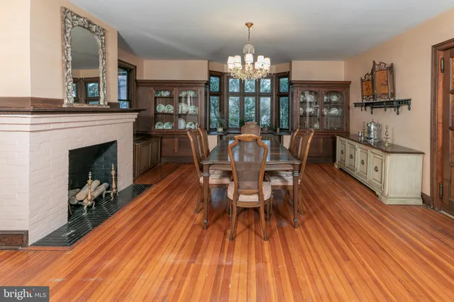 a dining room with furniture a fireplace and wooden floor