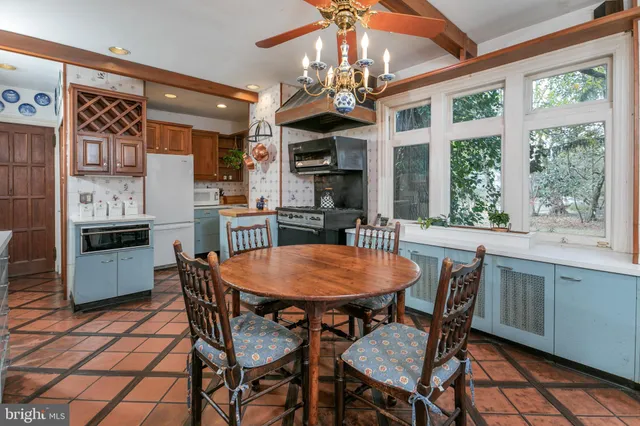 a dining room with stainless steel appliances granite countertop a dining table chairs and a refrigerator