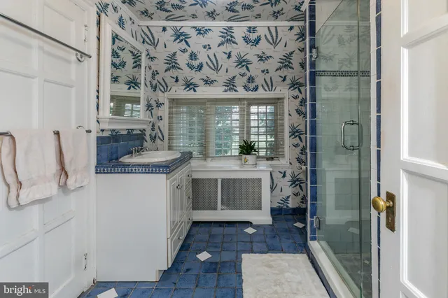 a bathroom with a granite countertop sink a mirror and shower