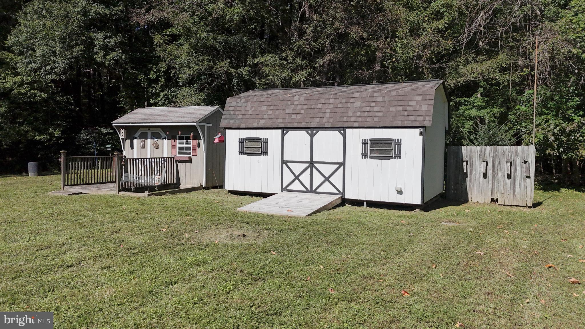 38340 Sugar Hole Road Avenue, MD 20609 - Photo 23 of 32 a backyard of a house with wooden fence and a large tree