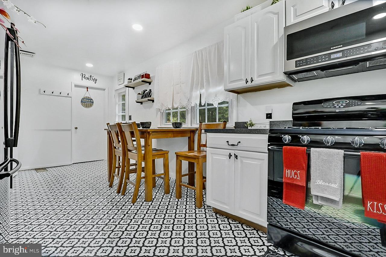 38340 Sugar Hole Road Avenue, MD 20609 - Photo 6 of 32 a kitchen with stainless steel appliances a stove a refrigerator a dining table and chairs