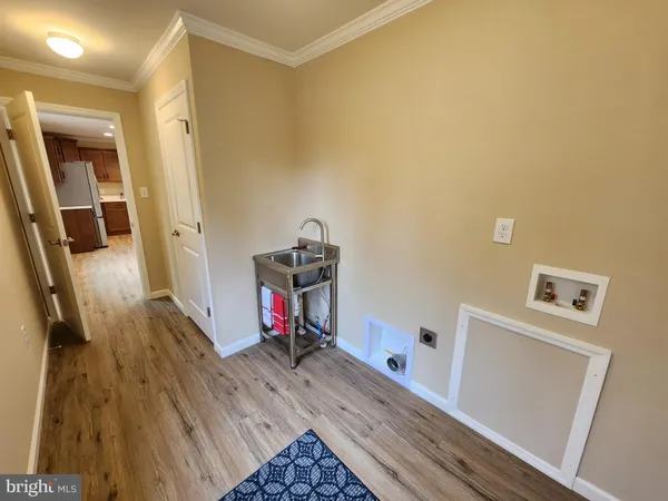 an empty room with wooden floor and entrance