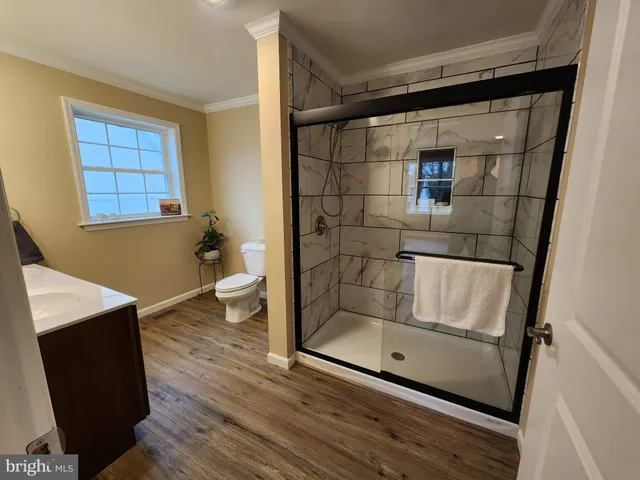 a white toilet sitting next to a bathroom sink and a mirror