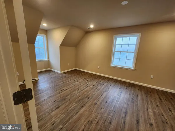 a large kitchen with stainless steel appliances a large counter top a refrigerator a stove a sink and a wooden floors