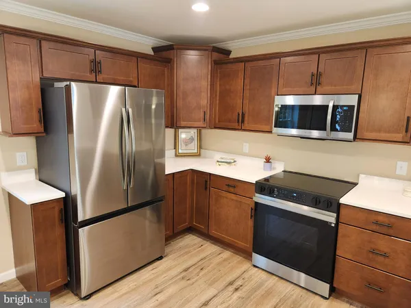 a kitchen with stainless steel appliances granite countertop wooden cabinets a refrigerator a stove a sink and a microwave