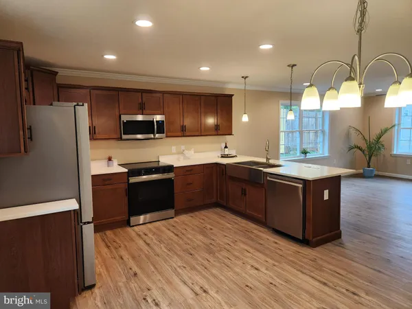 a kitchen with stainless steel appliances granite countertop a sink a stove and a wooden floor