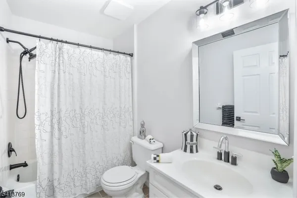 a bathroom with a sink a toilet and shower curtain