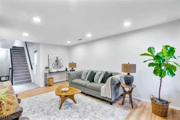 a living room with furniture potted plant and wooden floor
