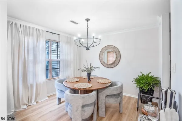 a dining room with chandelier fan and wooden floor