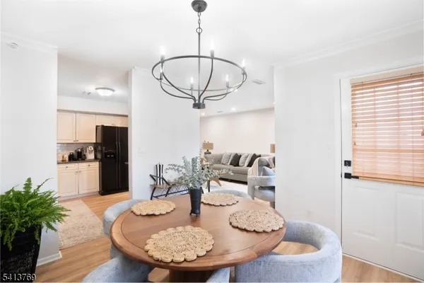 a living room with dining table couches wooden floor and kitchen view