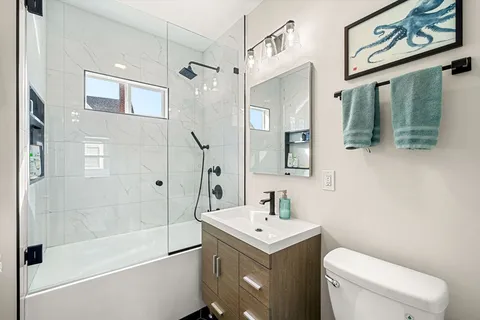 a bathroom with a sink a toilet and shower