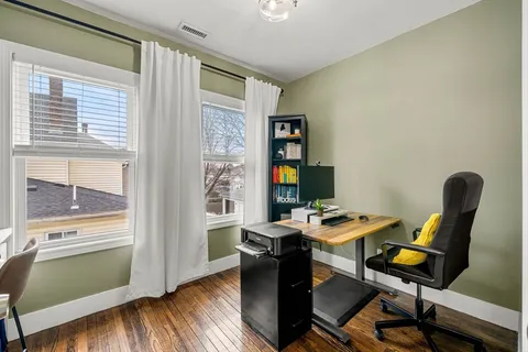 a view of a workspace with furniture and a window