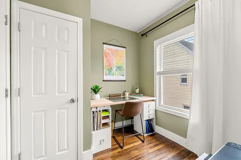 a view of a workspace with furniture and a window