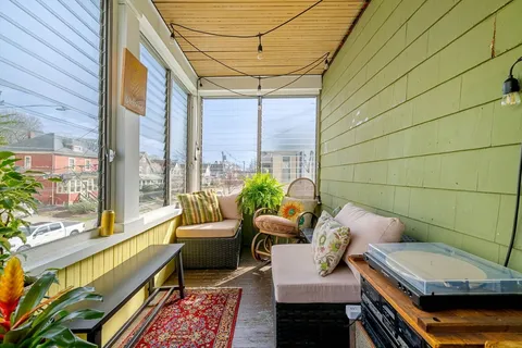 a balcony with furniture and a potted plant
